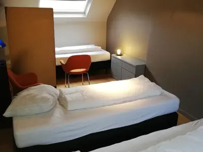 a small room with two beds and a chair at Villa in Zottegem with Pool and Sauna in Wolvenhoek