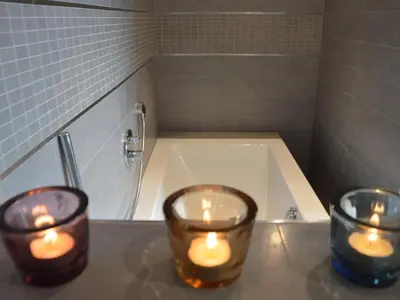 three candles are sitting on a counter in a bathroom at Villa in Zottegem with Pool and Sauna in Wolvenhoek