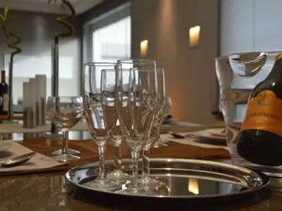 a table with wine glasses and a bottle of wine at Villa in Zottegem with Pool and Sauna in Wolvenhoek