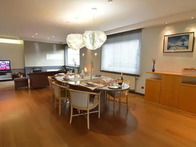 a dining room and living room with a table and chairs at Villa in Zottegem with Pool and Sauna in Wolvenhoek