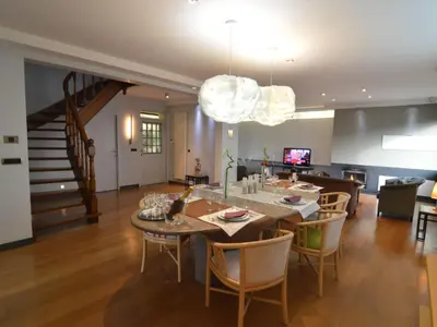 a dining room and living room with a table and chairs at Villa in Zottegem with Pool and Sauna in Wolvenhoek