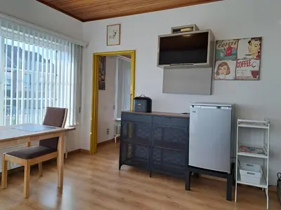 a living room with a desk and a tv on the wall at Apartment Capitalcondos in Ninove