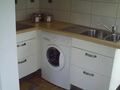 a kitchen with a washing machine and a sink at Apartment Capitalcondos in Ninove