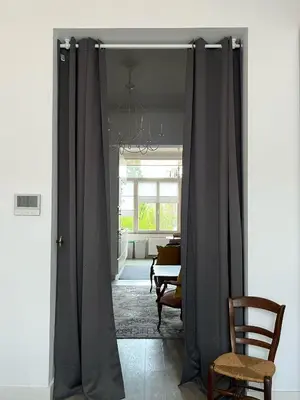a door with gray curtains in a living room at Appartement Voltaire in Brussels