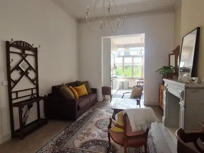 a living room with a couch and a fireplace at Appartement Voltaire in Brussels