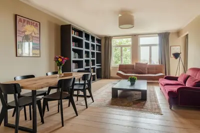 a living room with a table and chairs and a couch at Brussels EU Prestige residence in Brussels