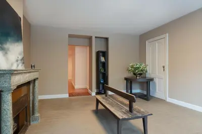 a living room with a bench and a fireplace at Brussels EU Prestige residence in Brussels