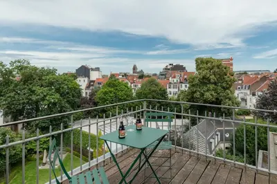 a table on a balcony with a view of a city at Brussels EU Prestige residence in Brussels