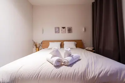 a bed with two towels and two towels at FLAX ANTWERP in Antwerp
