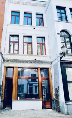 a white building with glass doors and windows at FLAX ANTWERP in Antwerp