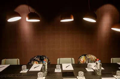 a dining room with a table and chairs and lights at Motel One Antwerp in Antwerp