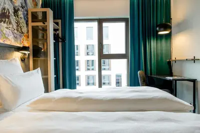 a bedroom with a white bed and a window at Motel One Antwerp in Antwerp