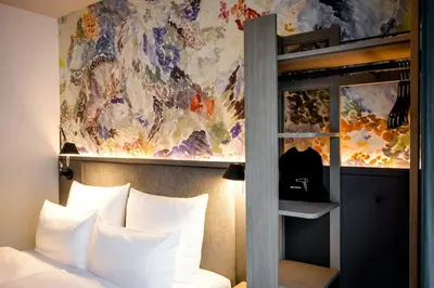 a bedroom with a bunk bed with a painting on the wall at Motel One Antwerp in Antwerp