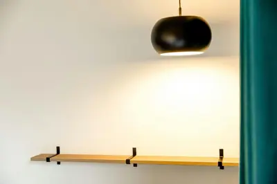 a wooden shelf on a wall with a black light at Motel One Antwerp in Antwerp