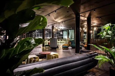 a room with plants and tables and chairs at Motel One Antwerp in Antwerp
