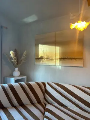 a living room with a couch and a painting on the wall at Chalet Leon in Geel