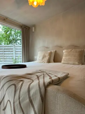 a bedroom with a large bed with a large window at Chalet Leon in Geel