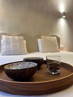 a wooden tray with bowls and a glass on a bed at Chalet Leon in Geel