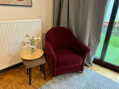 a red chair and a table with a vase of flowers at Garden loft in city center Meir 1FL in Antwerp