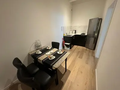a table and chairs in a room with a refrigerator at Garden loft in city center Meir 1FL in Antwerp