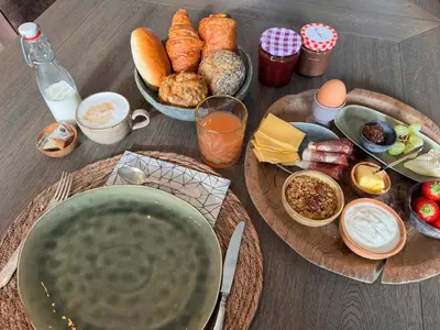 a table topped with plates of food and bread at B&B De Vreehoeve in Merksplas