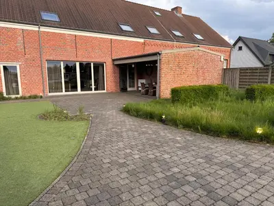 a brick building with a driveway in front of it at B&B De Vreehoeve in Merksplas