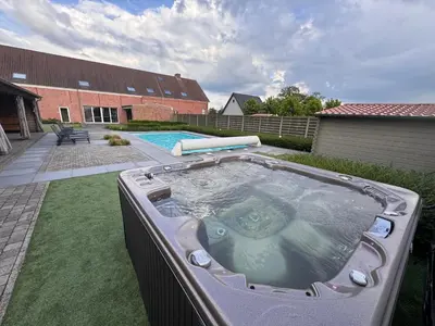 a large hot tub in the backyard of a house at B&B De Vreehoeve in Merksplas