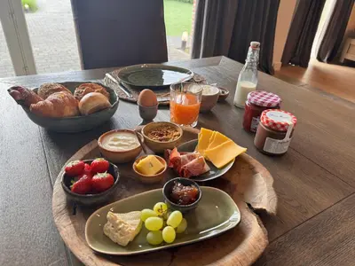 a table with a tray of breakfast foods on it at B&B De Vreehoeve in Merksplas