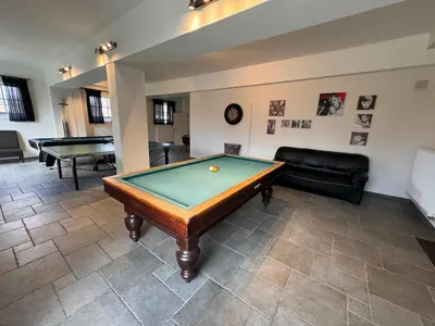 a living room with a pool table and a couch at B&B De Vreehoeve in Merksplas