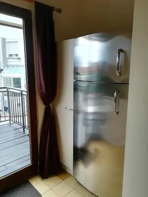 a stainless steel refrigerator in a kitchen with a balcony at Apparts Chez Odak in Brussels