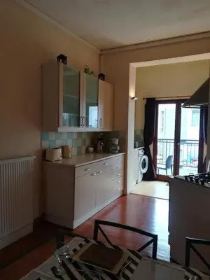a kitchen with white cabinets and a table in a room at Apparts Chez Odak in Brussels