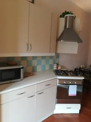 a kitchen with white cabinets and a stove top oven at Apparts Chez Odak in Brussels