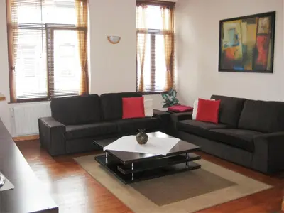 a living room with two couches and a coffee table at Apparts Chez Odak in Brussels