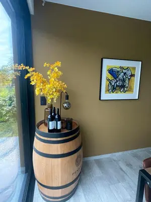 a barrel with bottles of wine and a plant at Villa Flandre in Berlare