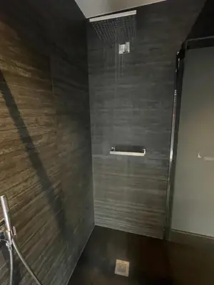 a bathroom with a shower with a wooden wall at Villa Flandre in Berlare