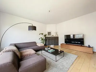 a living room with a couch and a flat screen tv at Churchill - Brugmann square in Brussels