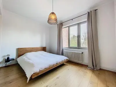 a bedroom with a bed and a large window at Churchill - Brugmann square in Brussels