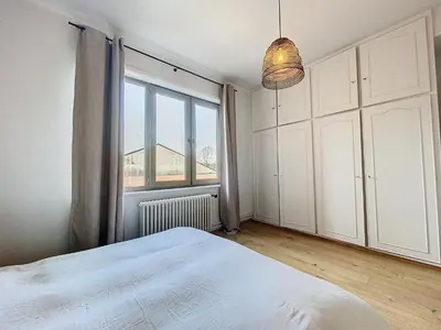 a bedroom with a bed and a large window at Churchill - Brugmann square in Brussels