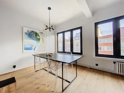 a dining room with a table and some windows at Churchill - Brugmann square in Brussels