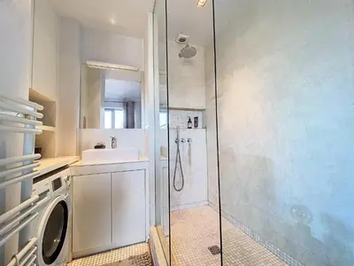 a bathroom with a shower and a washing machine at Churchill - Brugmann square in Brussels