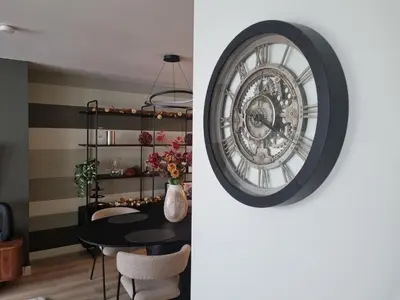 a dining room with a clock on the wall at Charlemagne in Mechelen
