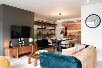 a living room with a couch and a dining room at Charlemagne in Mechelen