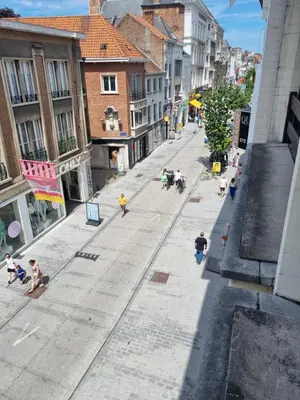 a group of people walking down a city street at Charlemagne in Mechelen