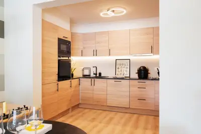 a kitchen with wooden cabinets and a table at Charlemagne in Mechelen