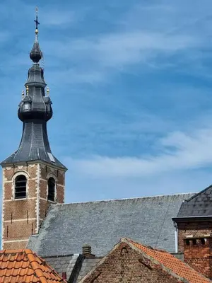 a church steeple with a cross on top of a building at Charlemagne in Mechelen