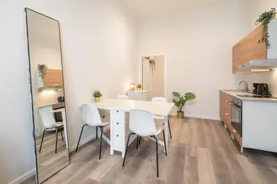a dining room with a table and chairs and a mirror at Cozy Antwerp City Apartments in Antwerp