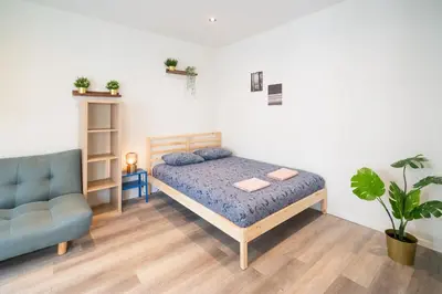 a bedroom with a bed and a blue chair at Cozy Antwerp City Apartments in Antwerp