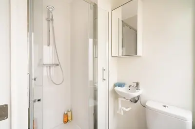 a white bathroom with a shower and a sink at Cozy Antwerp City Apartments in Antwerp