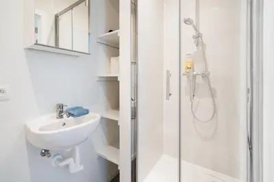 a white bathroom with a sink and a shower at Cozy Antwerp City Apartments in Antwerp