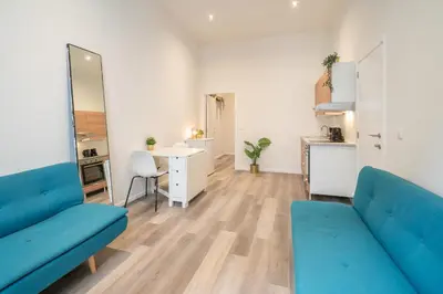 a living room with two blue couches and a table at Cozy Antwerp City Apartments in Antwerp